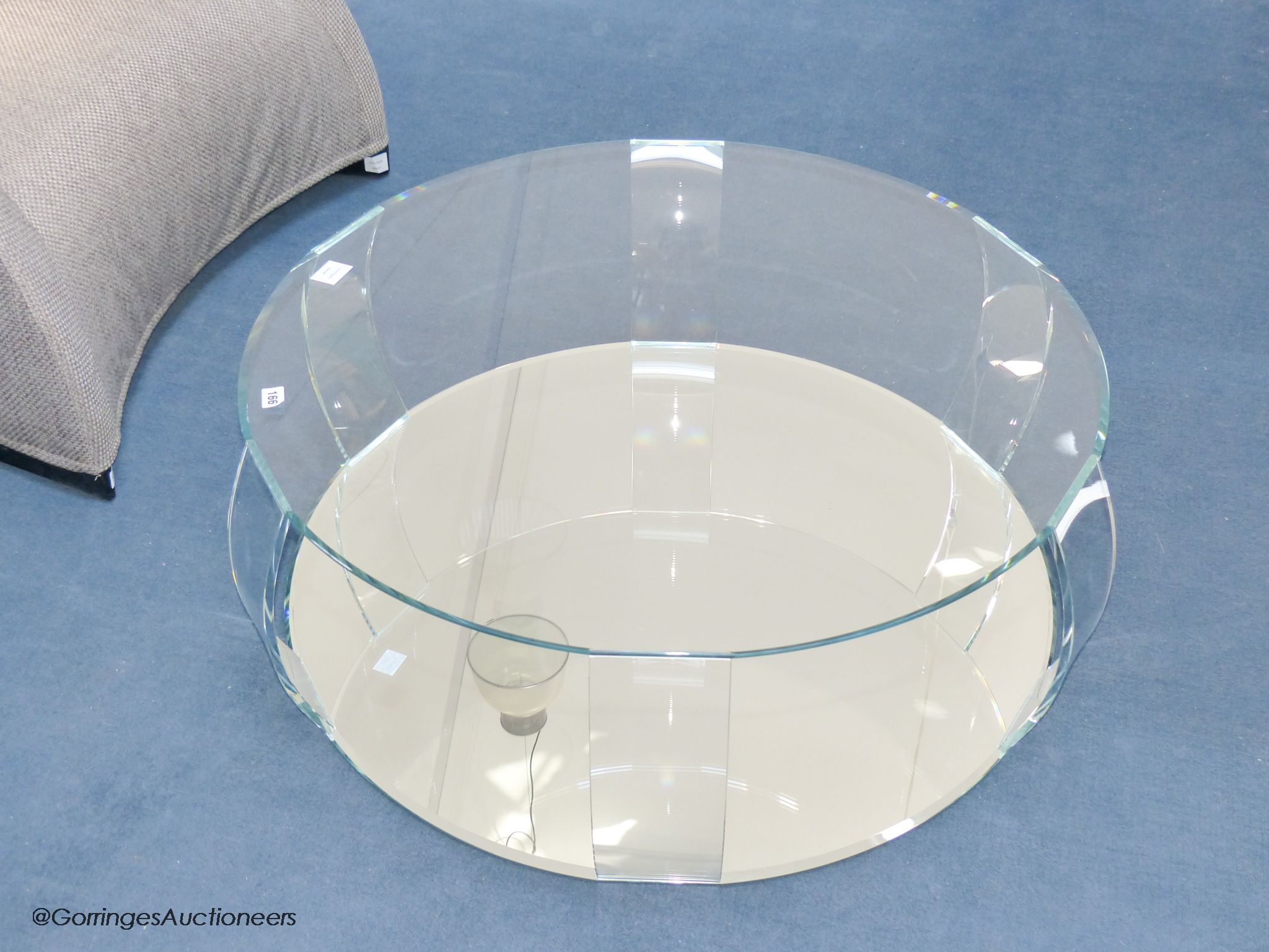 A contemporary glass circular coffee table, with mirrored base, 98 cm wide, 33 cm high